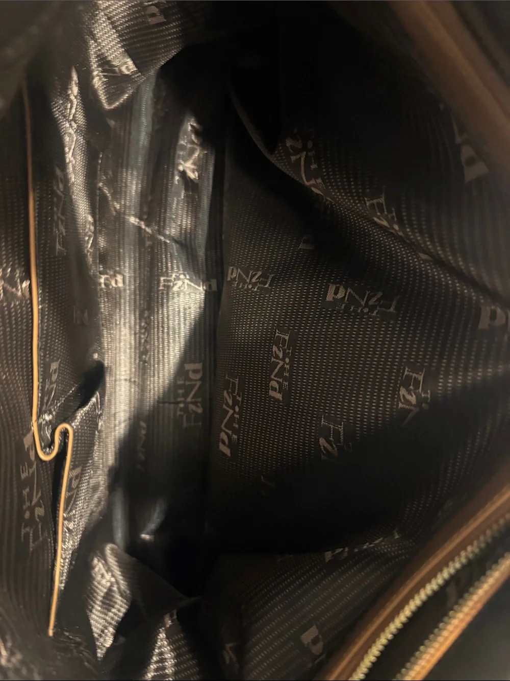 The Find Classic Tan Leather Weekender Travel Bag with Gold Hardware Buckle.